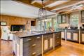 The kitchen with original wood paneled fireplace