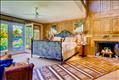 First floor master bedroom with fireplace and French doors to the patio and pool