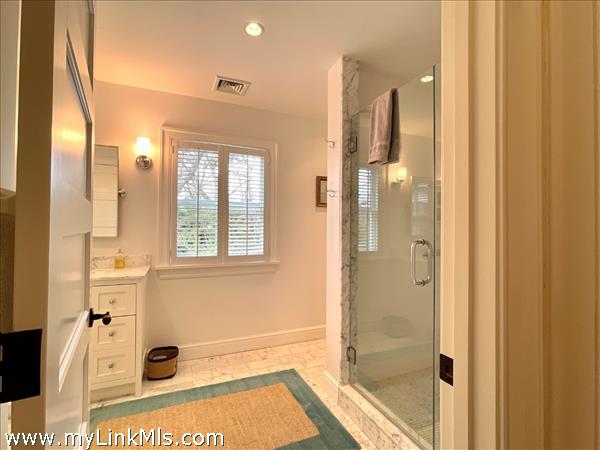 Private en-suite tile bath  for Bedroom 4 which enjoys a private hallway entrance with built-in closets.