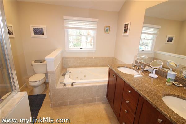 Private tiled bathroom with jetted tub and walk-in closet