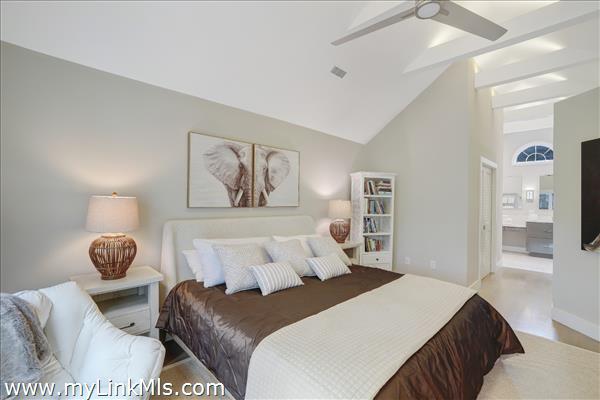 Primary bedroom with beamed cathedral ceilings, en suite bath & walk-in closet.