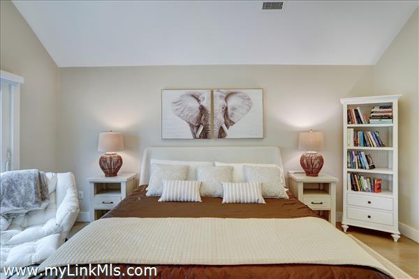 Primary bedroom with beamed cathedral ceilings, en suite bath & walk-in closet.