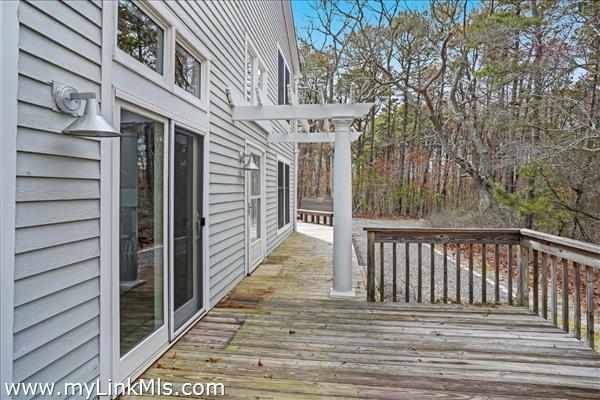 A large deck wraps around the exterior of the unit.
