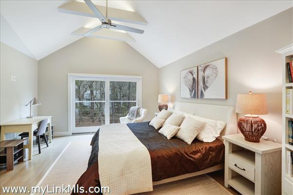 Primary bedroom with beamed cathedral ceilings, en suite bath & walk-in closet.