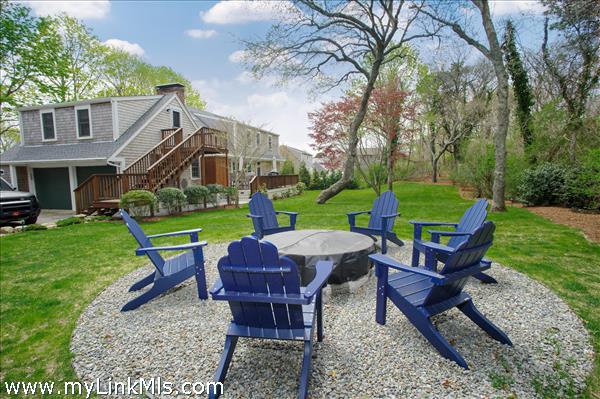 6+ person propane fire pit in corner of yard