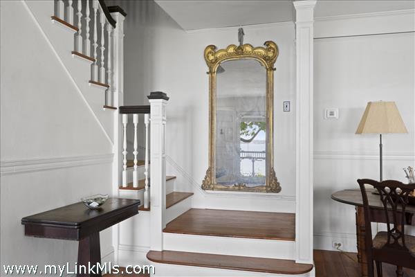 Front staircase with reflection of front entry in mirror