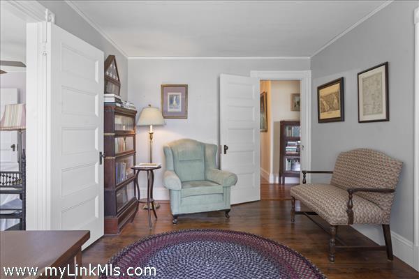 Bedroom/office with door to primary at left and hallway straight ahead