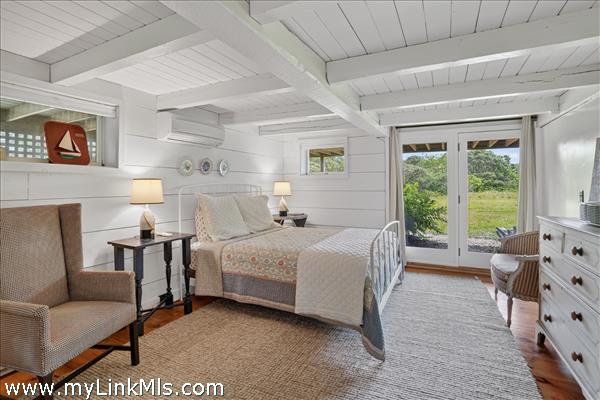 Lower-level bedroom with en suite bath and sliders out to the yard.