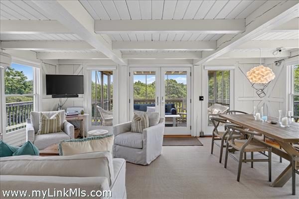 Living room opens to a screened porch and a side deck.