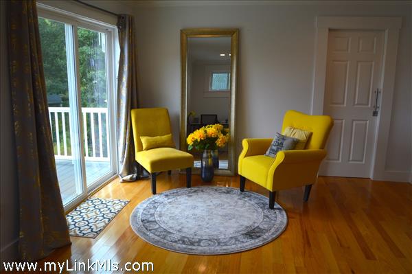 Sitting area leads to private balcony in primary bedroom