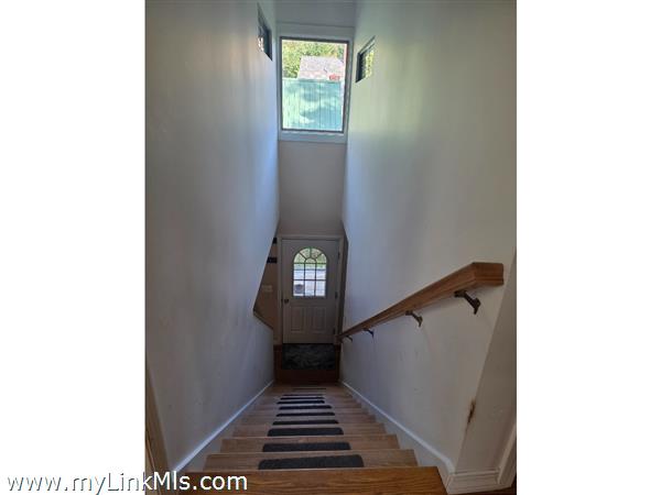 Front door opens looking up at the stairway to second floor