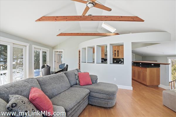 Livingroom to kitchen and deck. Primary private bedroom through the door on the left