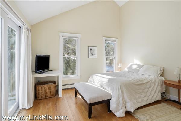 Primary bedroom with high vaulted ceiling.
