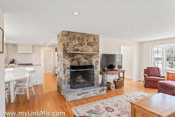 The kitchen and built-in banquette past the stone fireplace