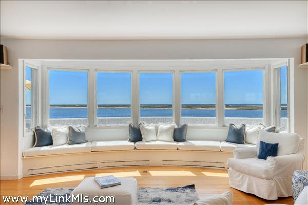 The living room with expansive window wall that offers panoramic views of Katama Bay