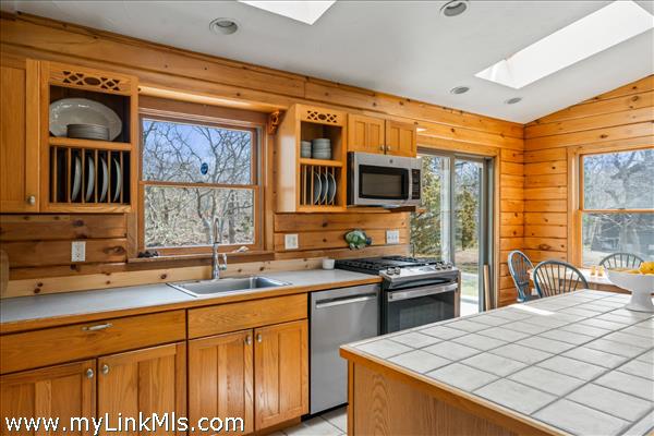 Guest house kitchen with casual dining area leading to large back deck, plus  center island and seating