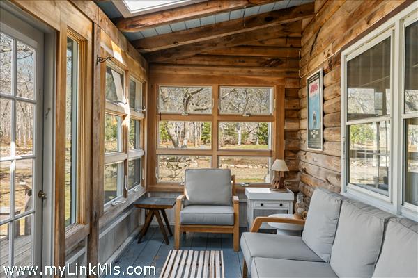 Enclosed porch leads from the living spaces to the front deck for seamless enjoyment of the many spaces.