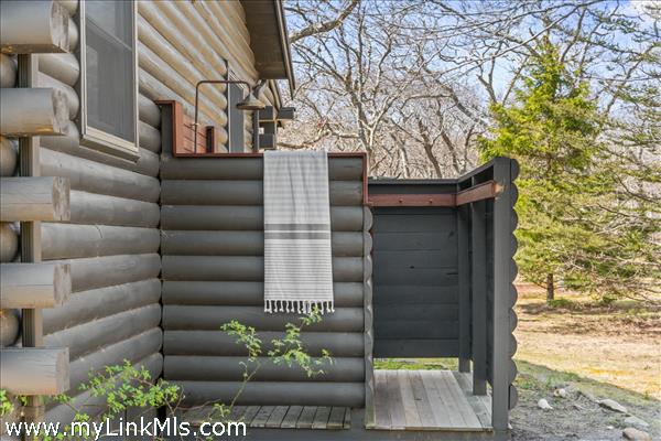 Beautiful copper hardware in custom outdoor shower with changing area