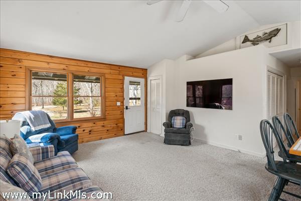 Open floor plan with vaulted ceilings, skylights and front door from the large porch and sliding doors to the enormous  back deck with bench seating, grill station and outdoor shower/dressing area