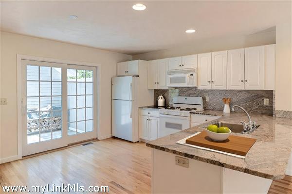 Sliders lead to side deck with outdoor shower and storage shed.