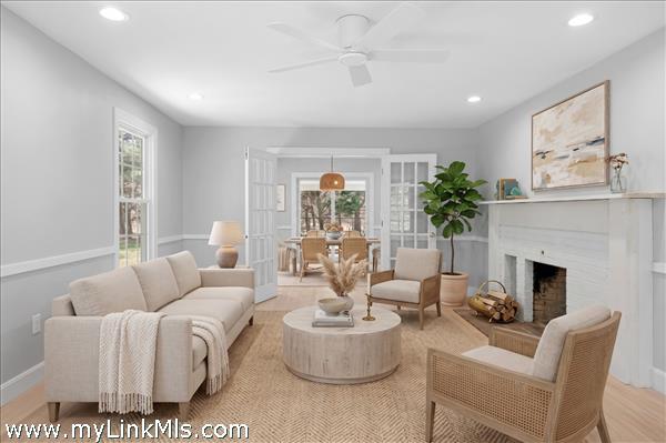 Large living room with Rumford fireplace with french doors that open to the dining room. Virtually staged.