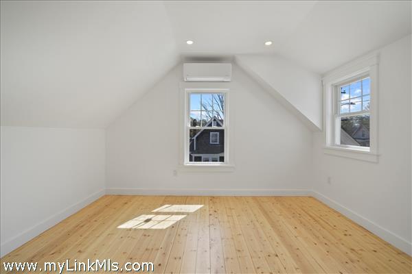Main bedroom in primary unit with hardwood oak flooring and climate control.