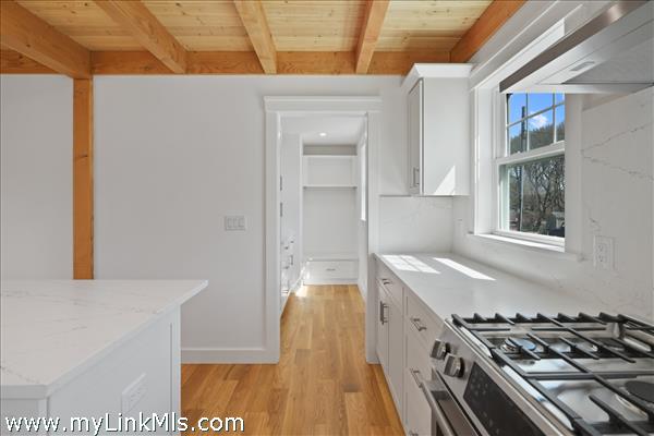 Gourmet kitchen flows to walk-in chef's pantry.
