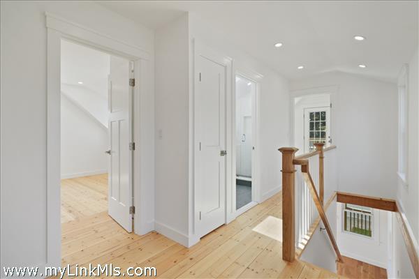 Second level landing and hallway to two bedrooms and full bathroom in primary unit.