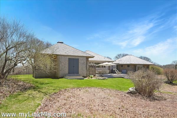 The back of the house has a large deck, storage and an outdoor shower.