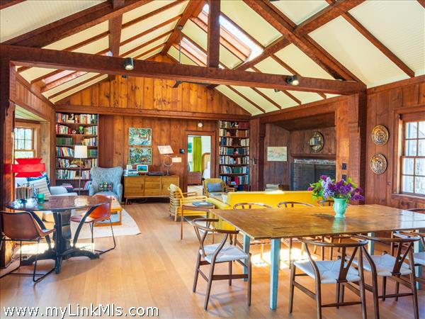 Great room with a fireplace, living room and dining room. Doors on both sides of the room leading to a private patio and firepit as well as a deck on the south side.