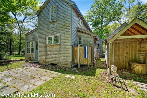Back of house with outdoor shower and Detached Shed