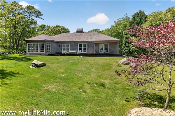 An expansive, sun-drenched deck on the back of the house that offers the perfect vantage point for outdoor entertaining, showcasing panoramic views of the beautiful rolling hills