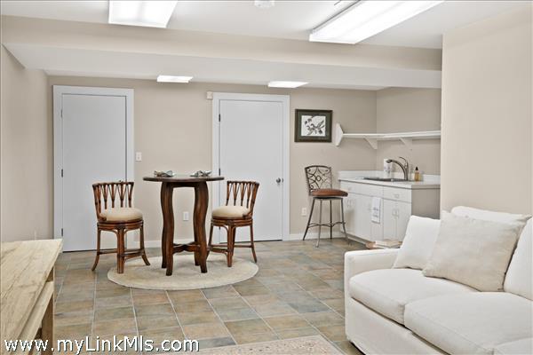 The finished lower level features a spacious, casual family room, an ideal secondary living space perfect for movie nights, relaxation, or quiet lounging
