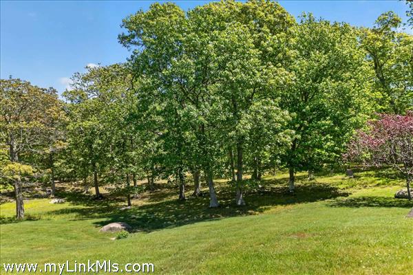 The property’s breathtaking acreage features scenic rolling hills accented by dramatic glacial boulders and lush, mature plantings that provide both vibrant seasonal color and exceptional privacy