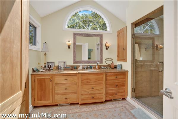 Spa-like primary bath with custom wood cabinetry and a double vanity