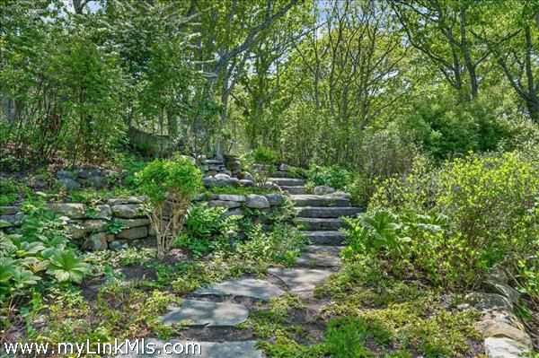 A beautifully landscaped, private woodland approach to the front door