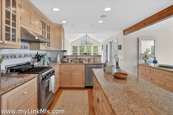 Open-concept kitchen featuring stainless steel appliances and custom cabinetry