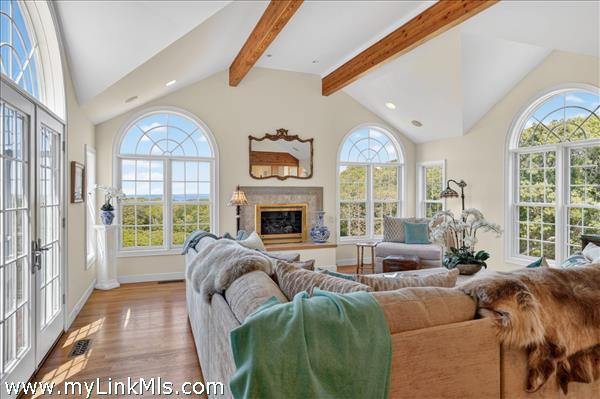 The heart of the home features an expansive, light-filled living room anchored by a beautiful fireplace
