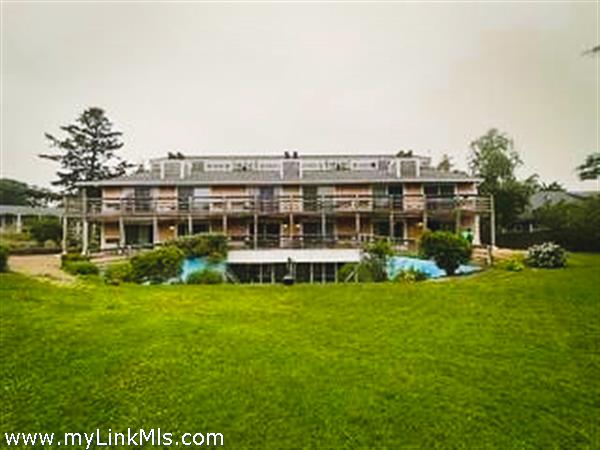 exterior of condo building looking over large grassy yard