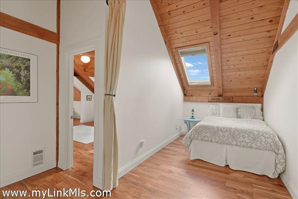 2nd floor loft area at top of stairs with entrance to primary suite to the left