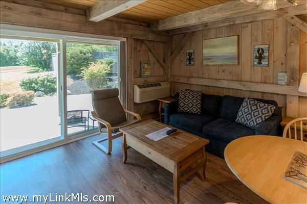 bright living room with slider access to patio common grounds and pool area