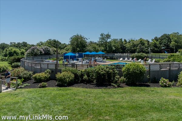 pool is surrounded by fencing and shrubbery for privacy
