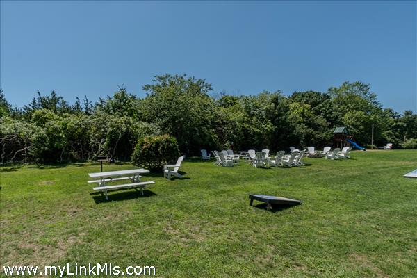 common area with picnic tables, corn hole games