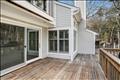 A large deck wraps around the exterior of the unit.