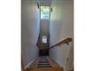 Front door opens looking up at the stairway to second floor