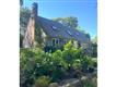 Beautiful front of house with stonewalls and plantings