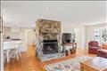 The kitchen and built-in banquette past the stone fireplace