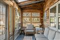 Enclosed porch leads from the living spaces to the front deck for seamless enjoyment of the many spaces.