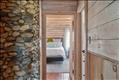 Coastal charm throughout - beach stone chimney looking toward primary bedroom