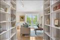 A welcoming foyer features timeless custom built-in bookshelves, perfect for showcasing a curated library or personal treasures